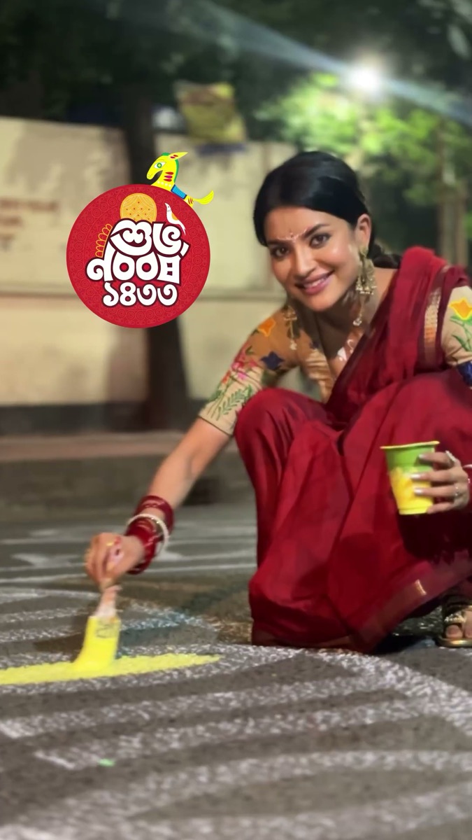 Nazifa Tushi in a red sari creating colorful street art